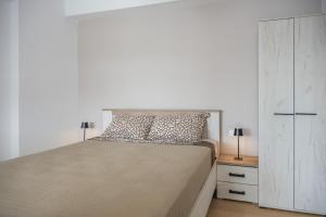a bedroom with a bed and a dresser with two lamps at Cretan View - Valley & Mountains View Sitia in Áyios Yeóryios +44 photos