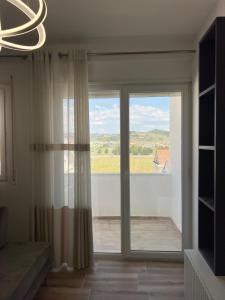 a room with a sliding glass door with a view at Ajans Apartament in Golem