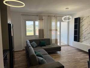 a living room with a couch and a television at Ajans Apartament in Golem