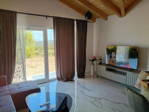 a living room with a large window and a tv at Vila Nikola in Pučišća