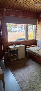 a room with a bed and a sink and a window at Ahlaistentupa in Pori