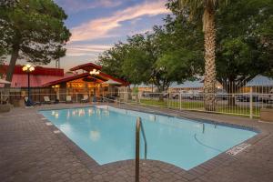 a large blue swimming pool in a courtyard at Best Western Swiss Clock Inn in Pecos