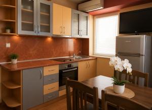 a kitchen with a table and a sink and a refrigerator at Hotel Maria in Vratsa