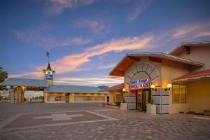 a building with a clock tower in the middle of a parking lot at Best Western Swiss Clock Inn in Pecos