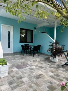 a patio with blue walls and tables and chairs at Arsi Beach House Rrjoll 2 in Baks-Rrjoll