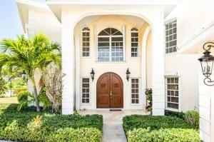 a house with a wooden door and a palm tree at Breathtaking Chalk Sound Private Pool Sunset Villa in Providenciales