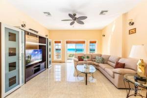 a living room with a couch and a tv at Breathtaking Chalk Sound Private Pool Sunset Villa in Providenciales