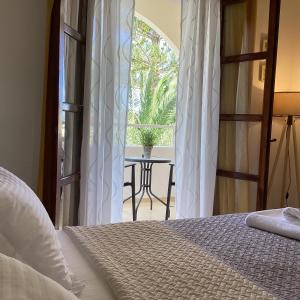 a bedroom with a bed and a window with a table at Santa Elena in Kamari