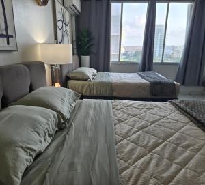 a hotel room with two beds and a window at Ritz Condo in San Juan +7 photos