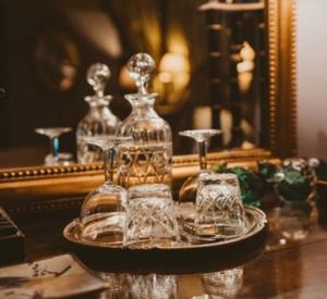 a plate with glasses on a table in front of a mirror at St Columbas Boutique BnB in Weobley