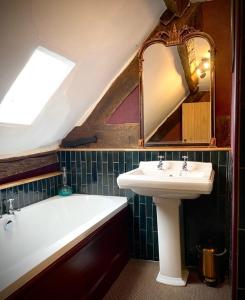 a bathroom with a sink and a bath tub at St Columbas Boutique BnB in Weobley +16 photos