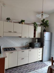 a kitchen with white cabinets and a white refrigerator at Domus Cesena in Cesena