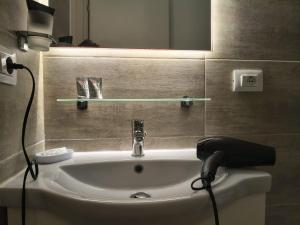 a bathroom with a sink and a lamp and a mirror at Domus Cesena in Cesena +47 photos