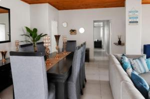 a dining room with a table and chairs at Serenity Six Beach House in Hibberdene