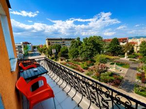 a balcony with red chairs and a view of a city at Hotel Maria in Vratsa