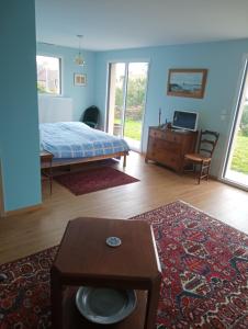 a bedroom with a bed and a table and a desk at Chez ALAIN & PATRICK in Vauville