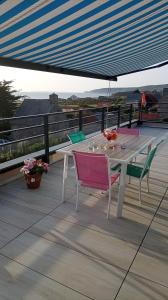 a white table and chairs on a deck at Chez ALAIN & PATRICK in Vauville