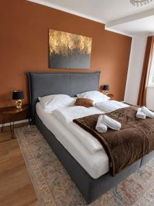 a bedroom with a large bed with brown walls at Harmony Hideaways I 90qm I Bergblick I 3 Balkone I seenah in Prien am Chiemsee
