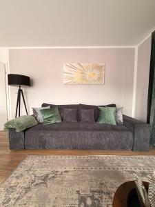 a couch in a living room with green pillows at Harmony Hideaways I 90qm I Bergblick I 3 Balkone I seenah in Prien am Chiemsee