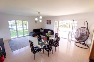 a living room with a glass table and chairs at Oasis Rest in Porto Martins