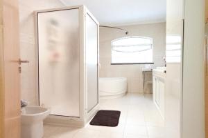 a bathroom with a shower and a toilet and a sink at Oasis Rest in Porto Martins +29 photos