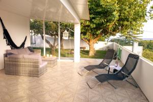 a patio with two chairs and a couch and a table at Oasis Rest in Porto Martins