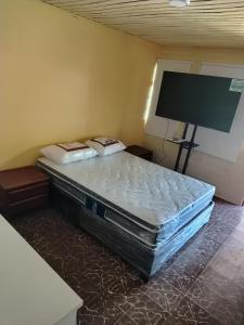 a bed in a room with a tv on the wall at Alto Luna casa de campo in La Tebaida