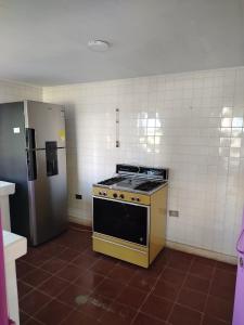 a kitchen with a stove and a refrigerator at Alto Luna casa de campo in La Tebaida