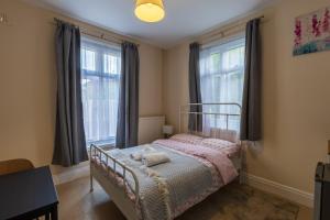 a bedroom with a bed and two windows at Clare - Double Room 20 mins walk to centre -Kitchenette Smart TV Shared bathroom in Chesterton