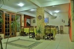 a restaurant with a table and chairs and a clock at Ayruma Guest House in Cabo Frio