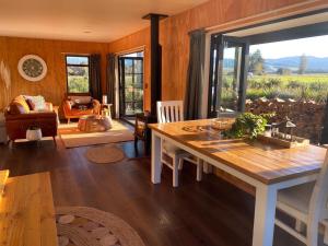a dining room with a table and a living room at Fiery Peak Eco-Retreat with Stargazing & Hot tub in Geraldine