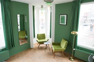 a living room with two chairs and a mirror at Little Duke Hotel in Den Bosch