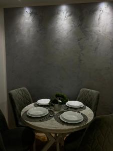 a dining table with plates at IN SILVER Apartman in Vršac +3 photos