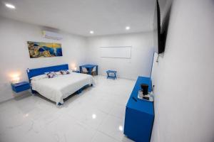a bedroom with a blue bed and two blue tables at Santorini Resort in Mérida +31 photos