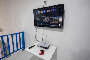 a flat screen tv hanging on a wall above a table at Santorini Resort in Mérida
