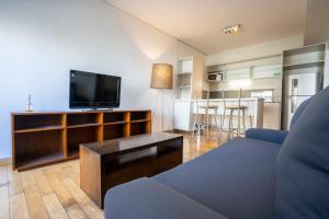 a living room with a couch and a flat screen tv at San Telmo Spa in Buenos Aires