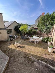 a patio with a table and chairs in a yard at Le Clos de Tuffeau in Turquant