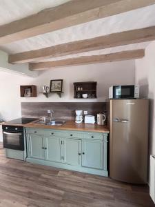 a kitchen with a sink and a refrigerator at Le Clos de Tuffeau in Turquant +8 photos
