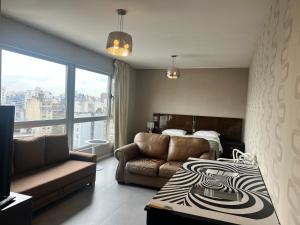 a bedroom with a bed and a couch and a window at San Telmo Spa in Buenos Aires +102 photos