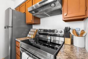a kitchen with a stove and a refrigerator at Sunny & Bright Charm with Community Pool in Tucson