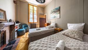 a bedroom with two beds and a fireplace at Authentic Flat in Dijon in Dijon