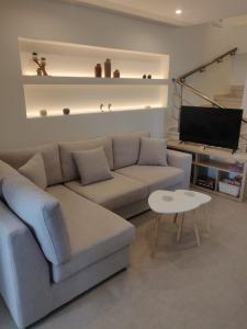 a living room with a couch and a tv at Fyki sea view apartment in Vlikhón