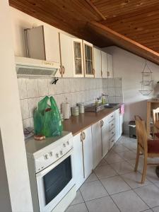 a kitchen with a white stove top oven next to a table at Đenovici Apartmans in Đenovići +5 photos