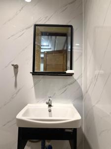 a white sink in a bathroom with a mirror at Serenity Home - 4 bedroom home in Iloilo City +33 photos