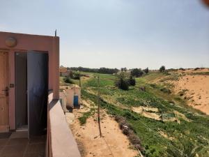 a door to a house in the middle of a field at انوايزم in Tiznit