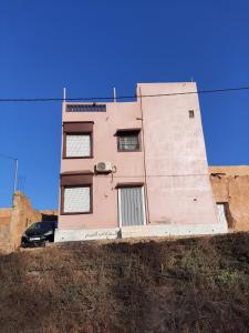 a pink building sitting on top of a hill at انوايزم in Tiznit