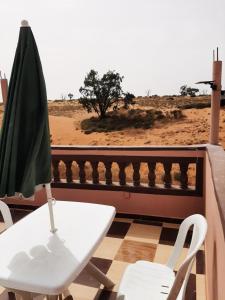 a table and chair on a balcony with a view of the desert at انوايزم in Tiznit