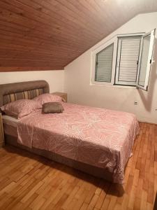 a bedroom with a bed and two windows at Đenovici Apartmans in Đenovići