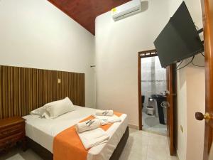 a bedroom with a bed and a television in it at Hotel Los Ángeles in Buga +29 photos