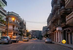 a street with cars driving down a city street at Résidence belhain jijel in Jijel